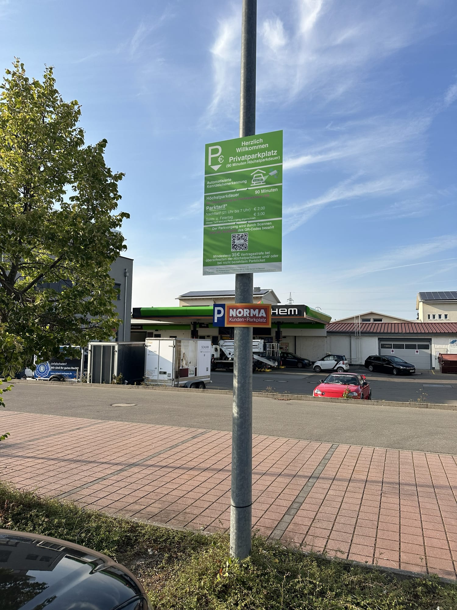 Parkerei-Tarifschild neben einem Schild Norma Kunden-Parkplatz, im Hintergrund die Norma-Filiale
